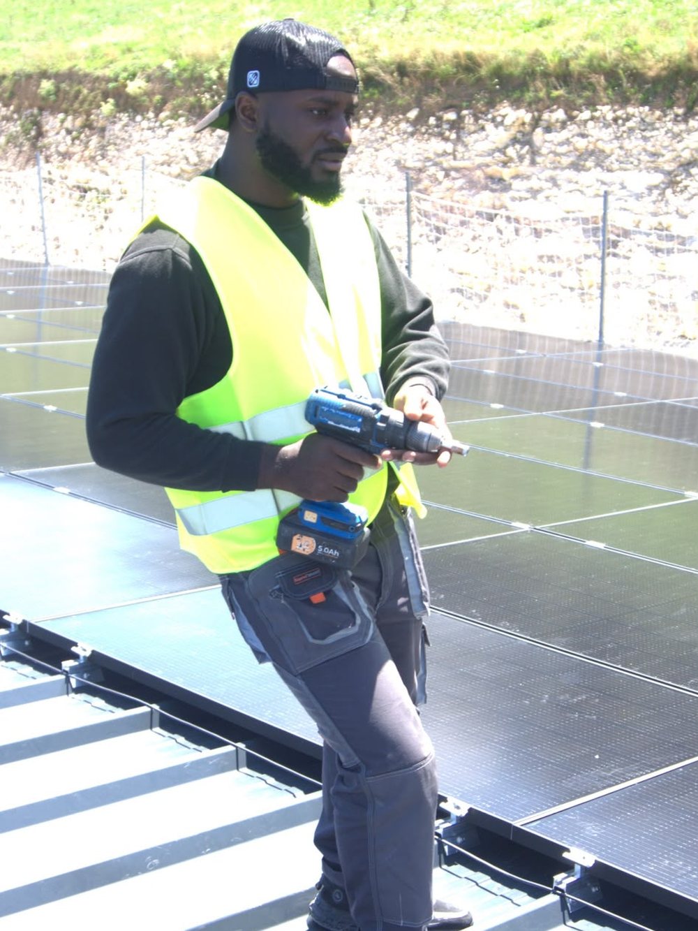 Lionel Béranger MFEGUE en intervention sur une toiture photovoltaïque, visseuse en main